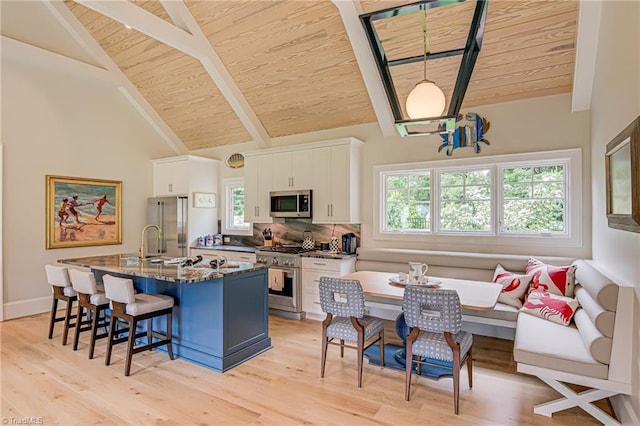 2632 Bartram Pl, Winston-Salem, NC 27106 - kitchen with premium appliances, a wooden ceiling with exposed beams, a breakfast bar, white cabinets, and a center island with sink