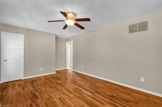 spare room with ceiling fan, a textured ceiling, and light wood-type flooring