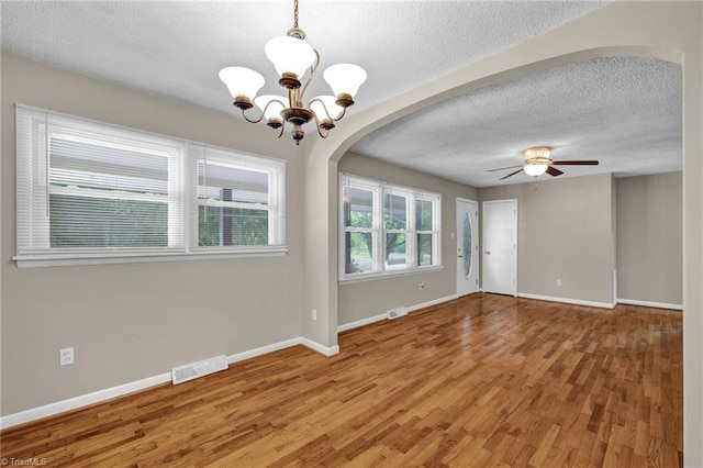 empty room featuring a textured ceiling, ceiling fan with notable chandelier, and hardwood / wood-style floors