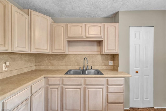 kitchen featuring light brown cabinetry, a textured ceiling, light hardwood / wood-style floors, and sink