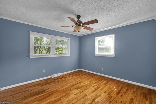 spare room with a wealth of natural light, light hardwood / wood-style floors, and ceiling fan