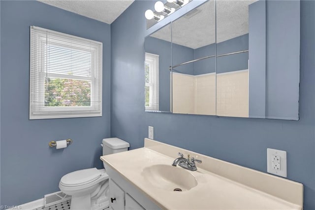 bathroom with a textured ceiling, a shower, vanity, and toilet