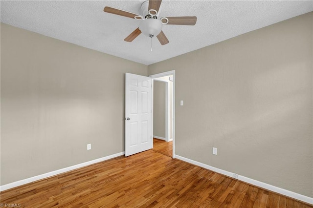 empty room featuring a textured ceiling, ceiling fan, and hardwood / wood-style flooring