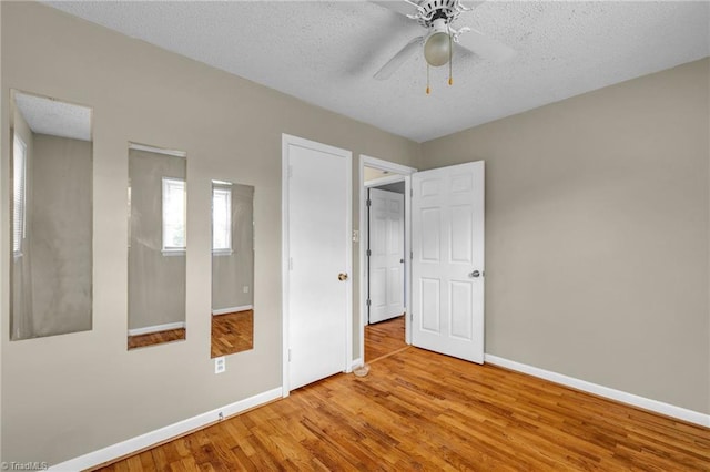 spare room featuring light hardwood / wood-style flooring, ceiling fan, and a textured ceiling