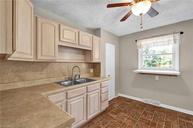 kitchen featuring a textured ceiling, sink, and ceiling fan