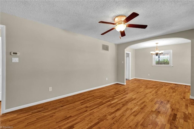 unfurnished room featuring hardwood / wood-style flooring, ceiling fan with notable chandelier, and a textured ceiling