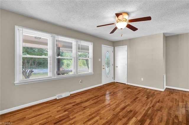 foyer with ceiling fan, hardwood / wood-style flooring, and a textured ceiling