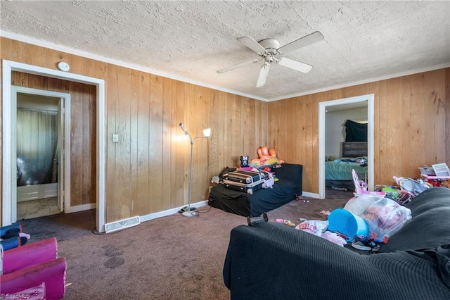 3410 Lambeth St, Winston-Salem, NC 27107 - carpeted living room with wood walls, ceiling fan, and a textured ceiling