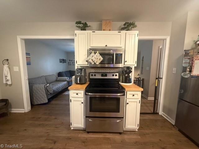 7098 E Fork Rd, High Point, NC 27265 - kitchen featuring appliances with stainless steel finishes, butcher block countertops, dark wood-style flooring, and baseboards