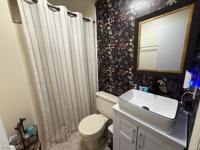7098 E Fork Rd, High Point, NC 27265 - bathroom featuring wallpapered walls, vanity, toilet, tile patterned floors, and curtained shower