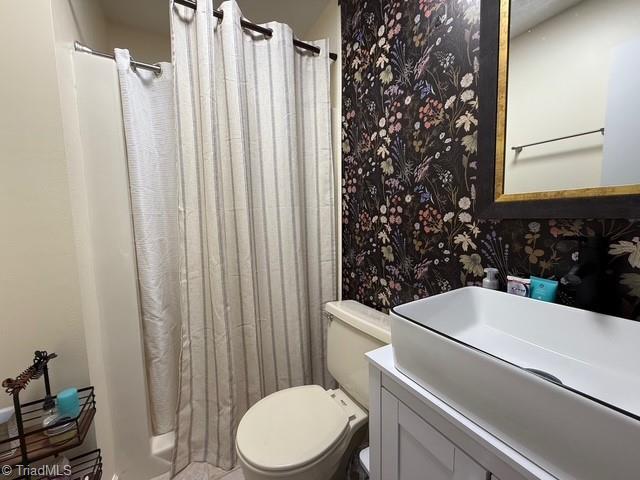 7098 E Fork Rd, High Point, NC 27265 - bathroom featuring toilet, vanity, wallpapered walls, and a shower with shower curtain
