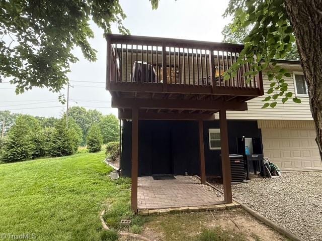 7098 E Fork Rd, High Point, NC 27265 - rear view of house featuring cooling unit, a yard, an attached garage, and a deck