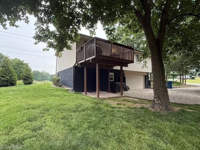 7098 E Fork Rd, High Point, NC 27265 - rear view of property featuring an attached garage, a deck, a yard, driveway, and cooling unit