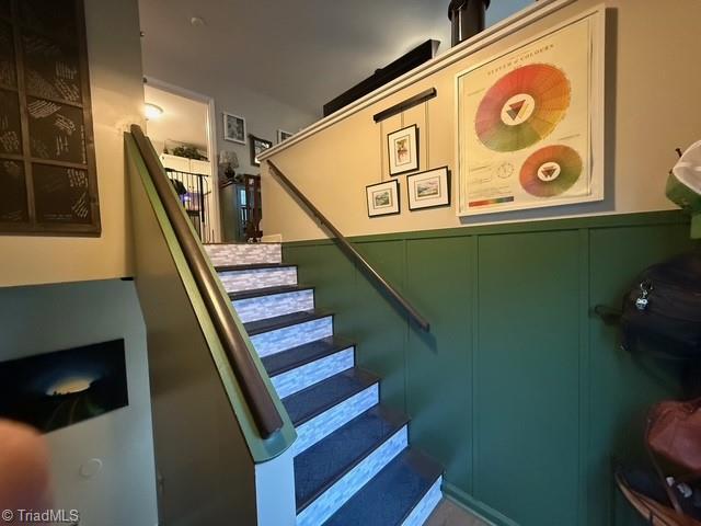 7098 E Fork Rd, High Point, NC 27265 - stairs featuring wainscoting and a decorative wall