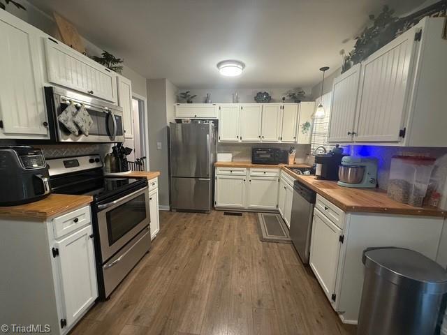 7098 E Fork Rd, High Point, NC 27265 - kitchen featuring butcher block counters, stainless steel appliances, dark wood-type flooring, and backsplash