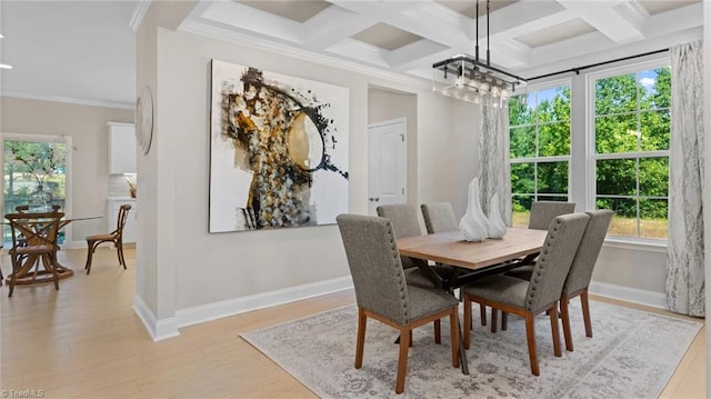 dining room featuring crown molding, light hardwood / wood-style floors, coffered ceiling, and a notable chandelier