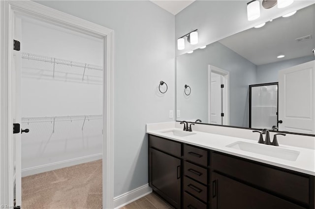6823 Magnolia Park Ct, Clemmons, NC 27012 - bathroom with double vanity, a shower stall, and a spacious closet