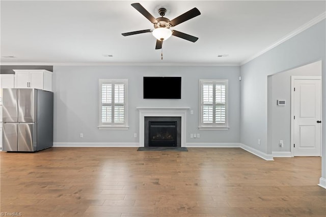 6823 Magnolia Park Ct, Clemmons, NC 27012 - unfurnished living room with crown molding, ceiling fan, a fireplace with flush hearth, and wood finished floors