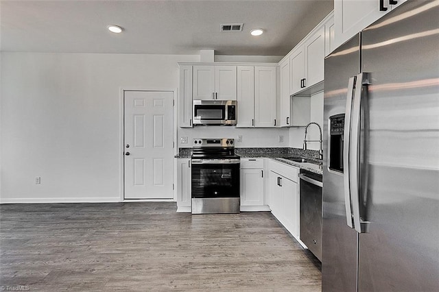 kitchen featuring sink, appliances with stainless steel finishes, white cabinets, and wood-type flooring