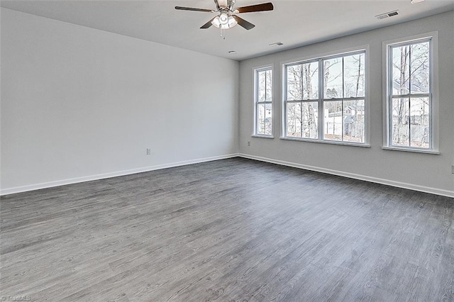 spare room with plenty of natural light, ceiling fan, and dark hardwood / wood-style floors