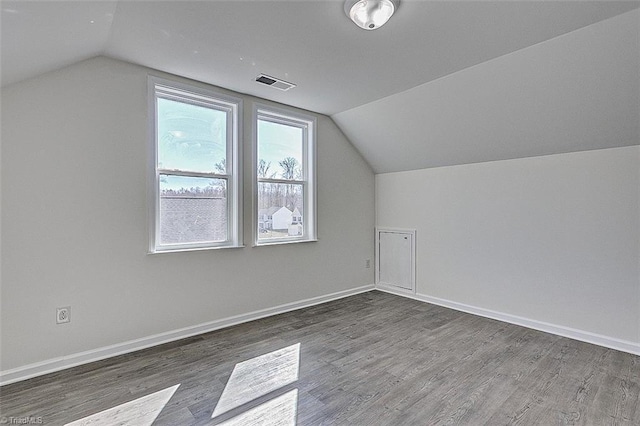 bonus room with dark wood-type flooring and lofted ceiling