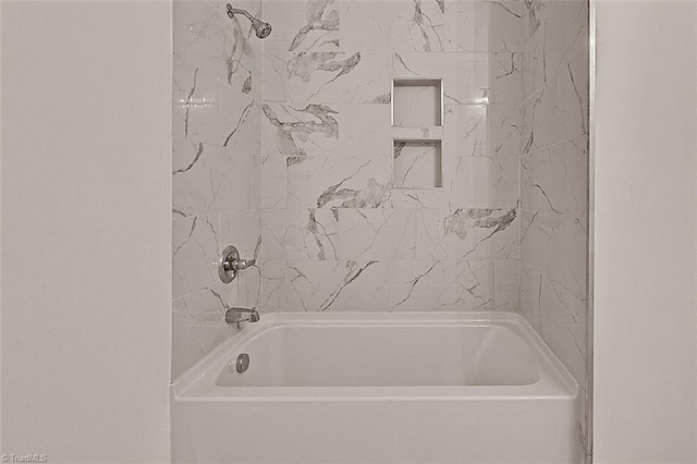 bathroom featuring tiled shower / bath