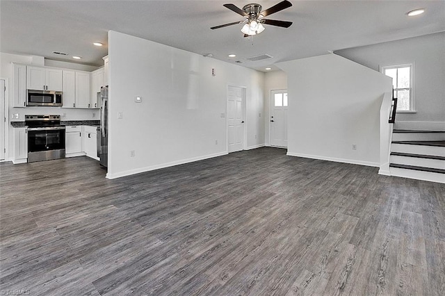 unfurnished living room featuring a healthy amount of sunlight, ceiling fan, and dark hardwood / wood-style flooring