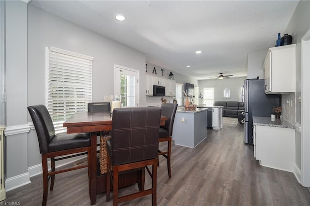 dining area with ceiling fan and dark wood-type flooring