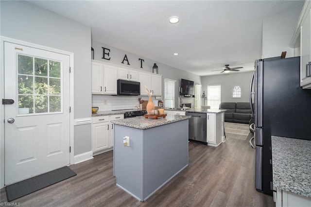 kitchen featuring appliances with stainless steel finishes, plenty of natural light, white cabinetry, and a kitchen island