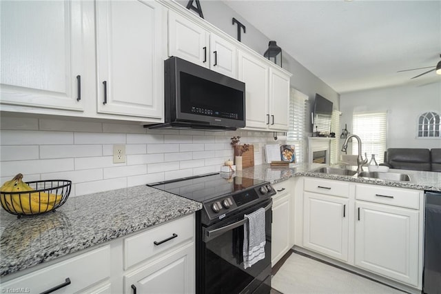 kitchen with tasteful backsplash, white cabinets, appliances with stainless steel finishes, and sink