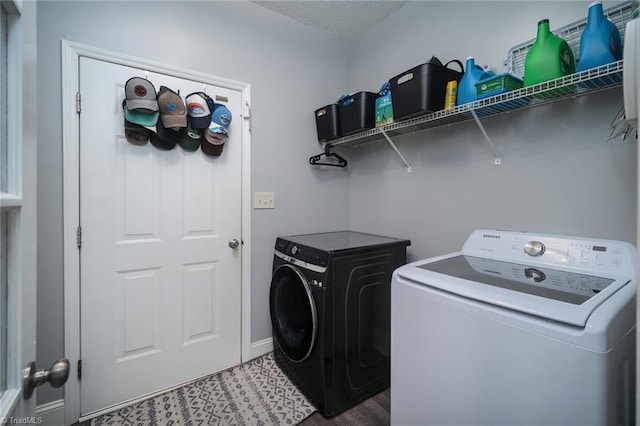 clothes washing area featuring wood-type flooring, a textured ceiling, and washer and clothes dryer