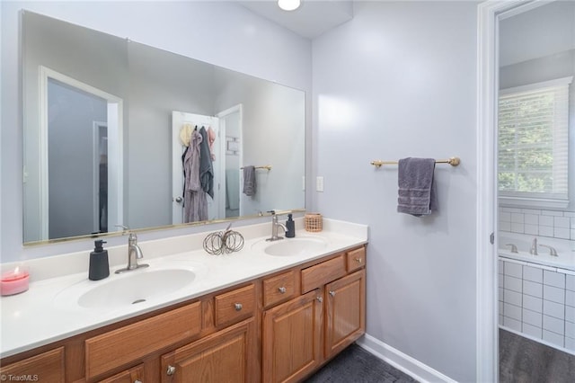 bathroom with a relaxing tiled tub and vanity