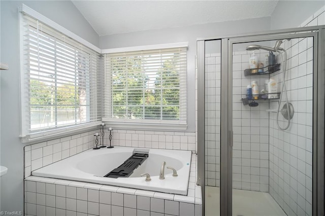 bathroom featuring a textured ceiling, lofted ceiling, and shower with separate bathtub