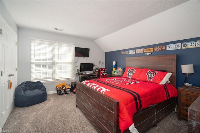 carpeted bedroom featuring vaulted ceiling and a textured ceiling