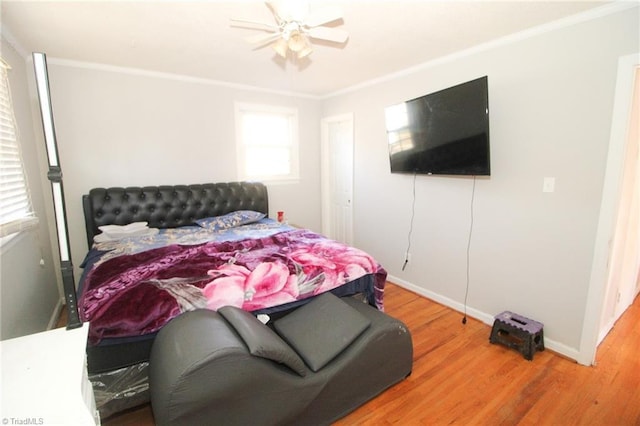 bedroom with hardwood / wood-style flooring, ceiling fan, crown molding, and multiple windows