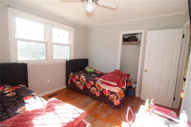 bedroom with ceiling fan, crown molding, and light hardwood / wood-style flooring