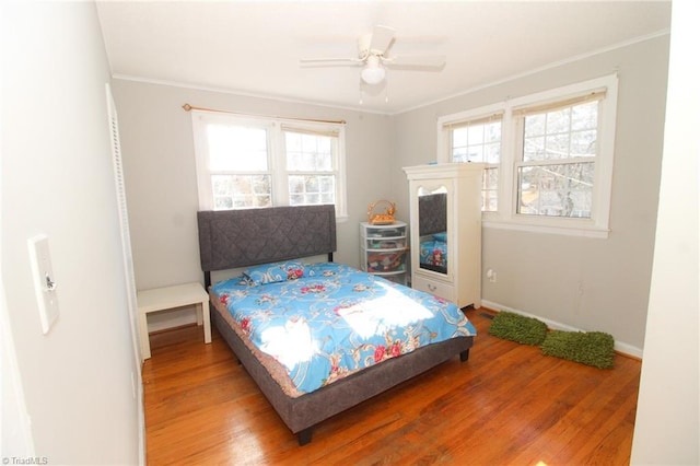 bedroom featuring ceiling fan, crown molding, and wood-type flooring