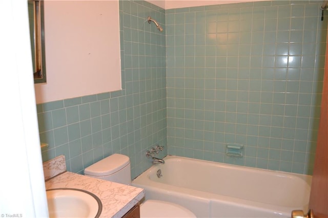 full bathroom with toilet, vanity, and tiled shower / bath