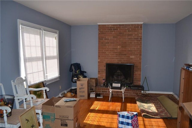 living room with hardwood / wood-style floors and a brick fireplace