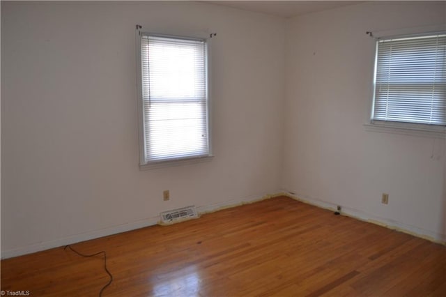 unfurnished room with hardwood / wood-style floors