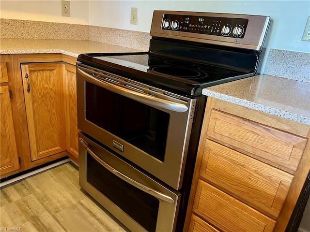 3638 Morris Farm Dr, Greensboro, NC 27409 - kitchen featuring double oven range, brown cabinets, and light wood-style floors