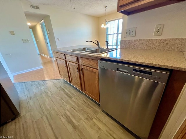 3638 Morris Farm Dr, Greensboro, NC 27409 - kitchen with stainless steel dishwasher, a sink, brown cabinets, a textured ceiling, and decorative light fixtures