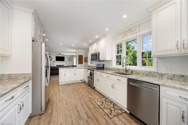 1101 Shalimar Ct, High Point, NC 27262 - kitchen with appliances with stainless steel finishes, a sink, light wood-style floors, open floor plan, and white cabinets