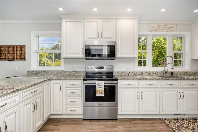 1101 Shalimar Ct, High Point, NC 27262 - kitchen with appliances with stainless steel finishes, a sink, crown molding, white cabinets, and light stone countertops