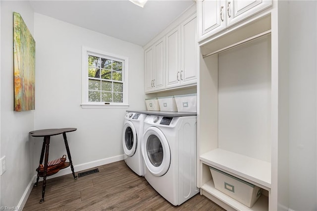 1101 Shalimar Ct, High Point, NC 27262 - laundry area featuring washing machine and clothes dryer, wood finished floors, cabinet space, and baseboards