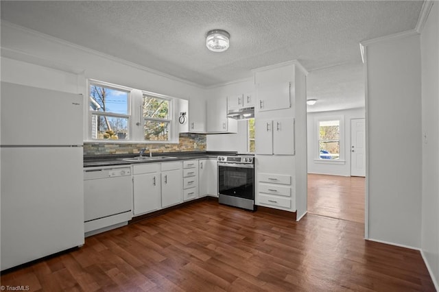 kitchen featuring dark wood finished floors, tasteful backsplash, dark countertops, white appliances, and under cabinet range hood