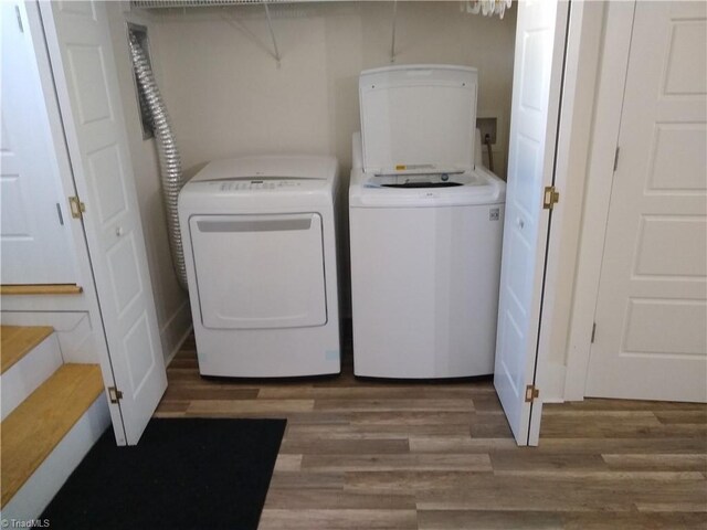 laundry room with washing machine and dryer and hardwood / wood-style flooring