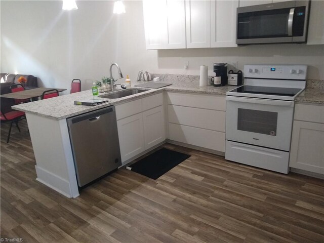 kitchen featuring appliances with stainless steel finishes, sink, dark hardwood / wood-style flooring, and white cabinets