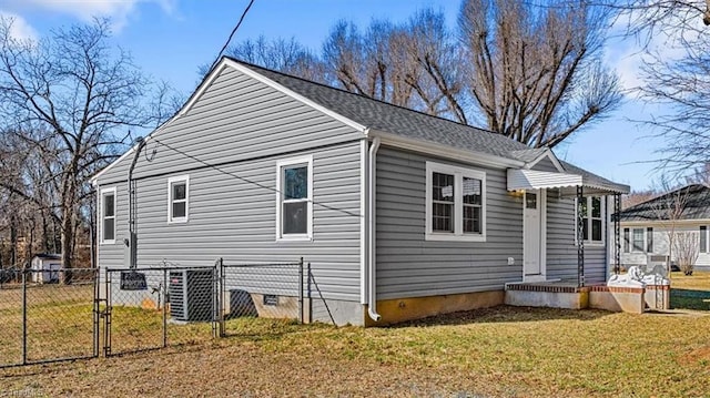 view of side of home featuring roof with shingles, crawl space, a gate, fence, and a yard