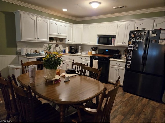 866 Trinity Church Rd, Tobaccoville, NC 27050 - kitchen featuring black appliances, crown molding, white cabinetry, dark wood-style floors, and a wainscoted wall
